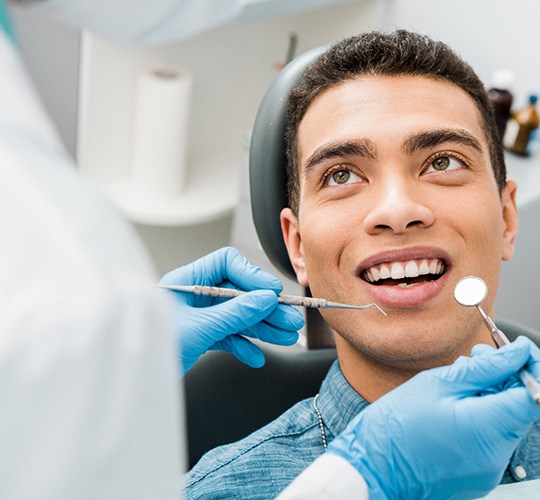 a man having his teeth examined at a dental office