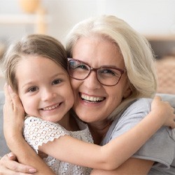 woman smiling while hugging young girl 