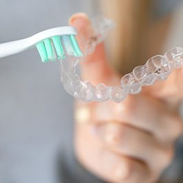 closeup of person cleaning clear aligner 